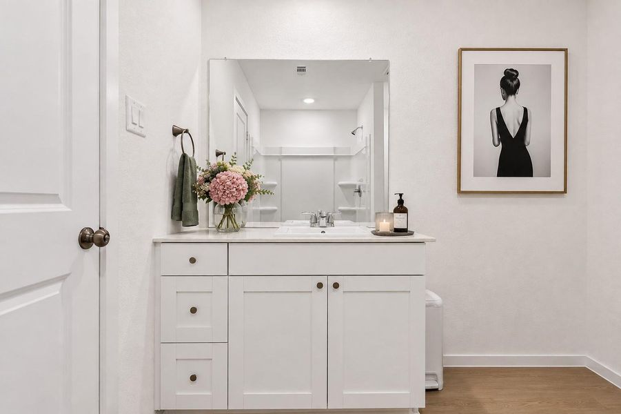 The primary bath continues the home's clean, modern feel with a spacious vanity area.