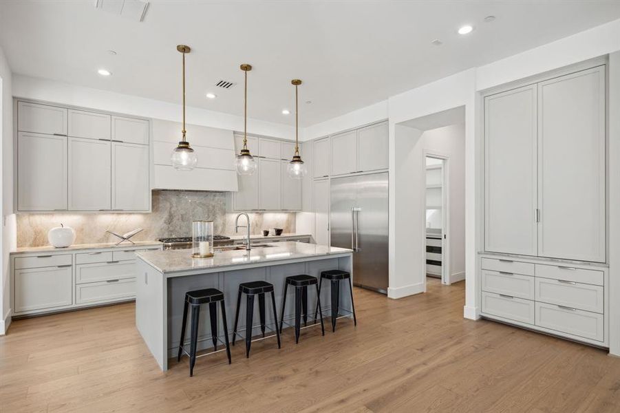 The heart of this home is a stunning kitchen featuring quartzite countertops, illuminated cabinetry, and top-of-the-line Thermador appliances. You have plenty of storage space!