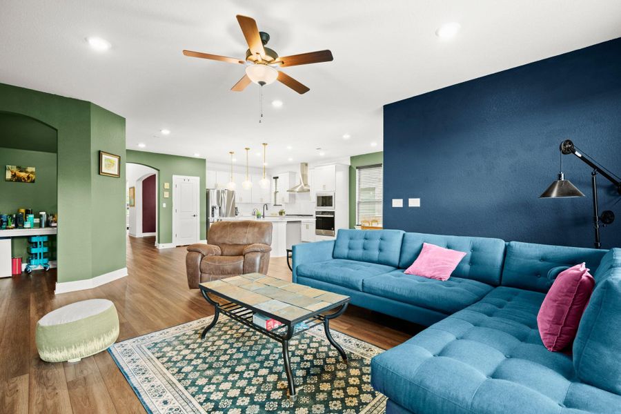 Living room with wood finished floors, arched walkways, ceiling fan, and recessed lighting Living room with wood finished floors, arched walkways, ceiling fan, and recessed lighting