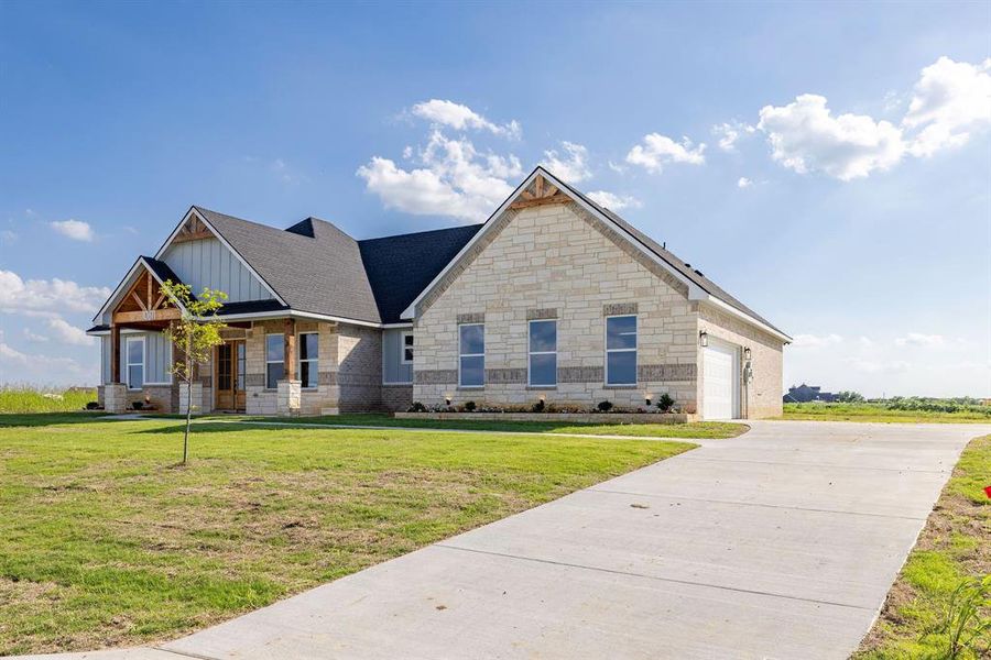 Craftsman-style home featuring driveway, board and batten siding, a garage, and a front lawn Craftsman-style home featuring driveway, board and batten siding, a garage, and a front lawn