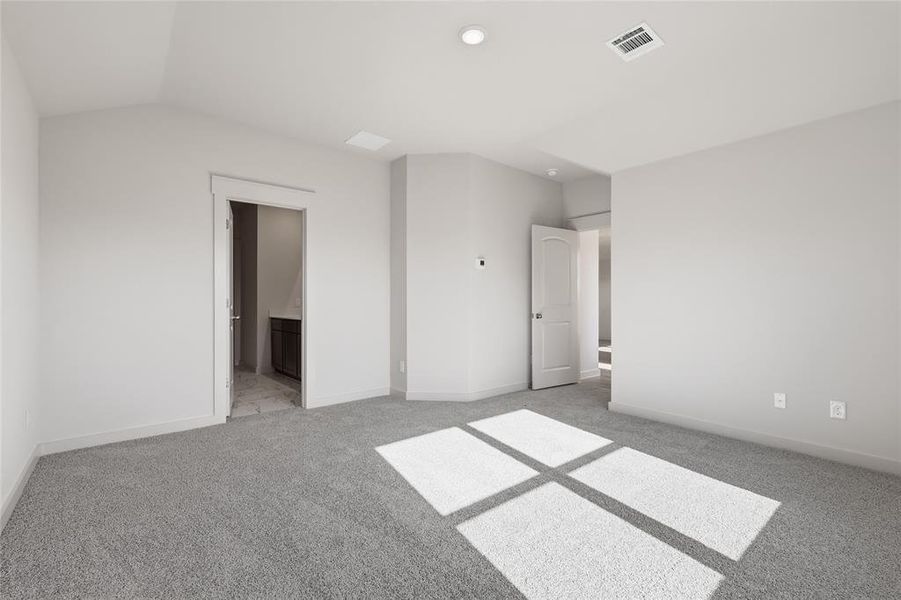 Unfurnished bedroom with connected bathroom and light colored carpet