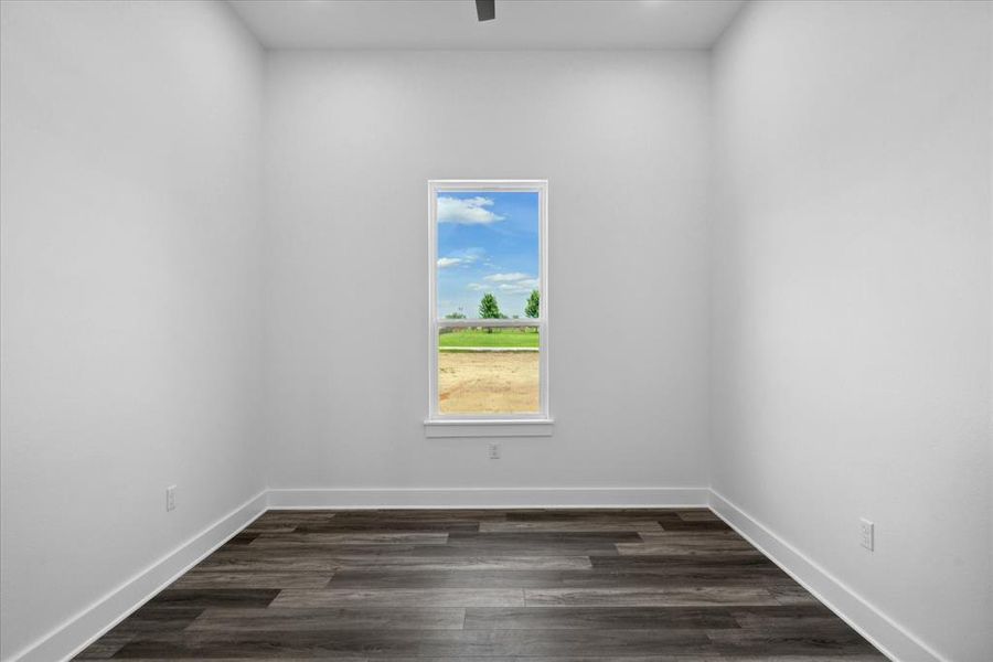 Spare room with baseboards and dark wood finished floors