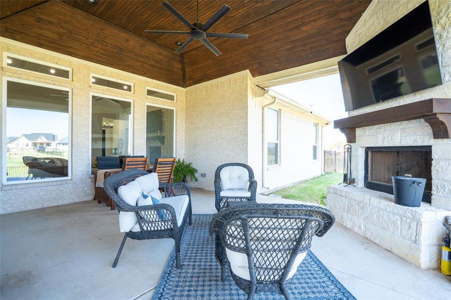 View of patio / terrace with a ceiling fan and an outdoor living space with a fireplace