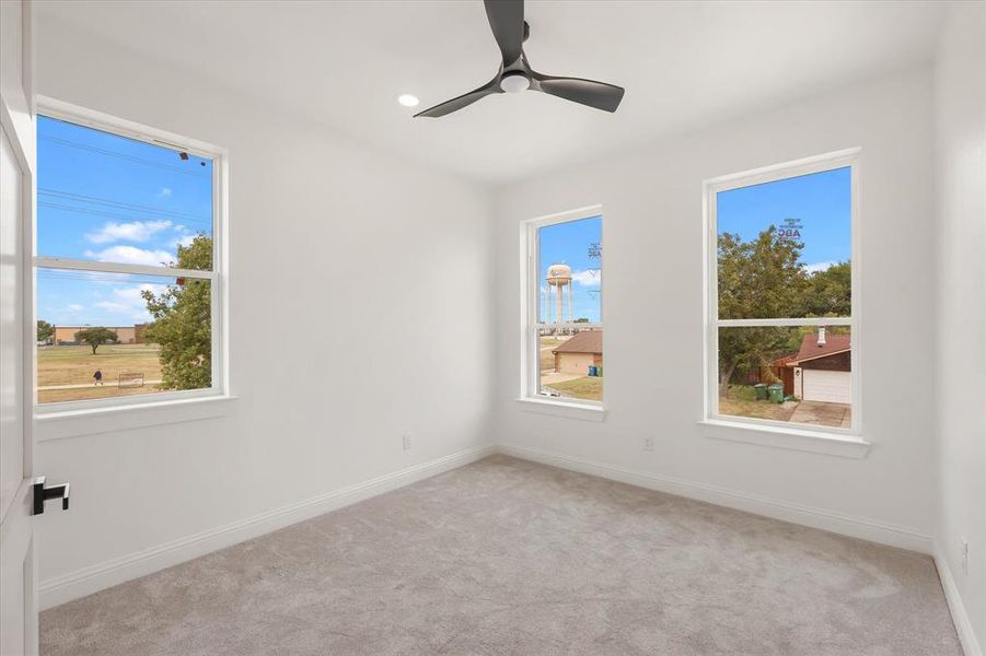 Empty room with carpet, healthy amount of natural light, ceiling fan, and recessed lighting Empty room with carpet, healthy amount of natural light, ceiling fan, and recessed lighting
