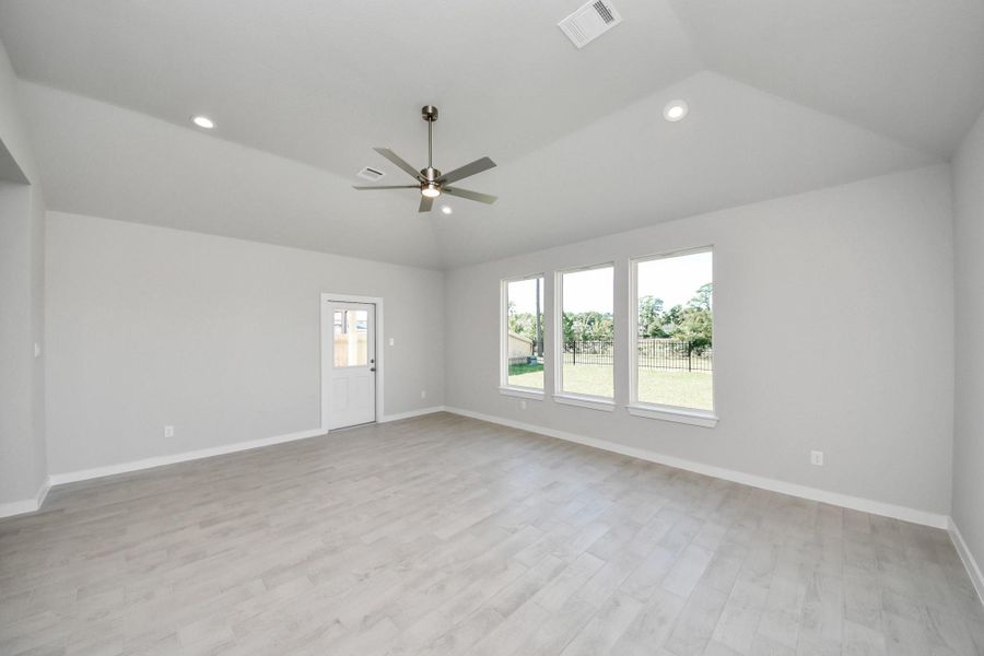 Welcome family and guests to your charming living room! With its high ceilings, recessed lighting, ceiling fan, custom paint, beautiful flooring, and large windows that let in abundant natural light, this room is perfect for gatherings. Sample photo of completed home with similar floor plan. Actual colors and selections may vary.
