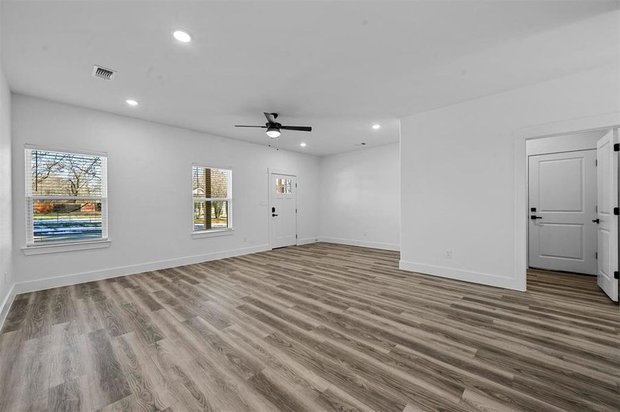 Empty room with ceiling fan and light hardwood / wood-style floors