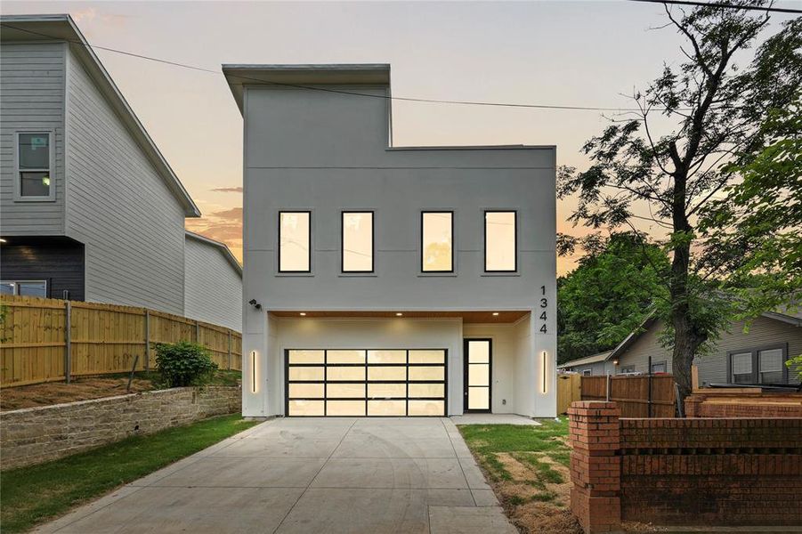 Contemporary house featuring stucco siding, driveway, and an attached garage Contemporary house featuring stucco siding, driveway, and an attached garage