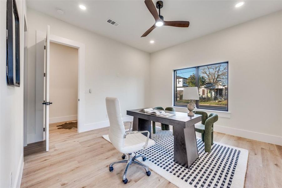 Bright interior room featuring wood-finish flooring, a contemporary ceiling fan, recessed lighting, a large window, and wide baseboards