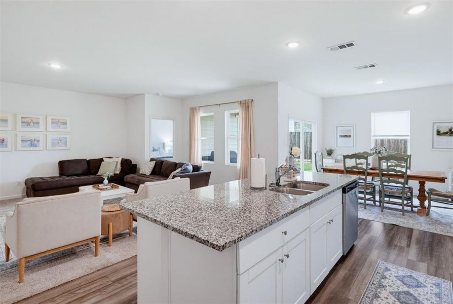Kitchen island featuring a double-basin stainless steel sink and granite countertop