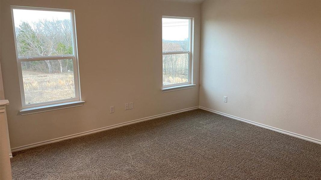 Empty room with dark colored carpet and baseboards