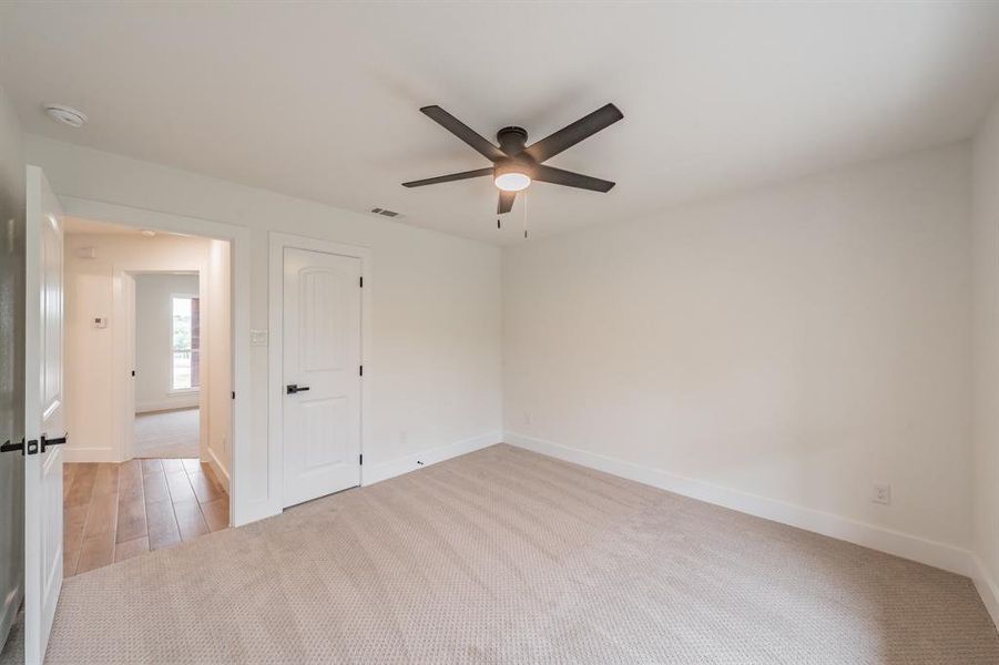 Unfurnished room featuring ceiling fan, a smoke detector, baseboards, and light carpet