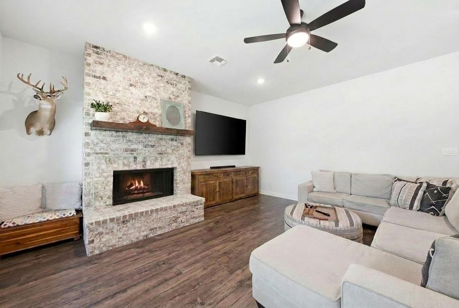 A striking whitewashed brick fireplace anchors this inviting living space, complemented by rich hardwood flooring. A striking whitewashed brick fireplace anchors this inviting living space, complemented by rich hardwood flooring.