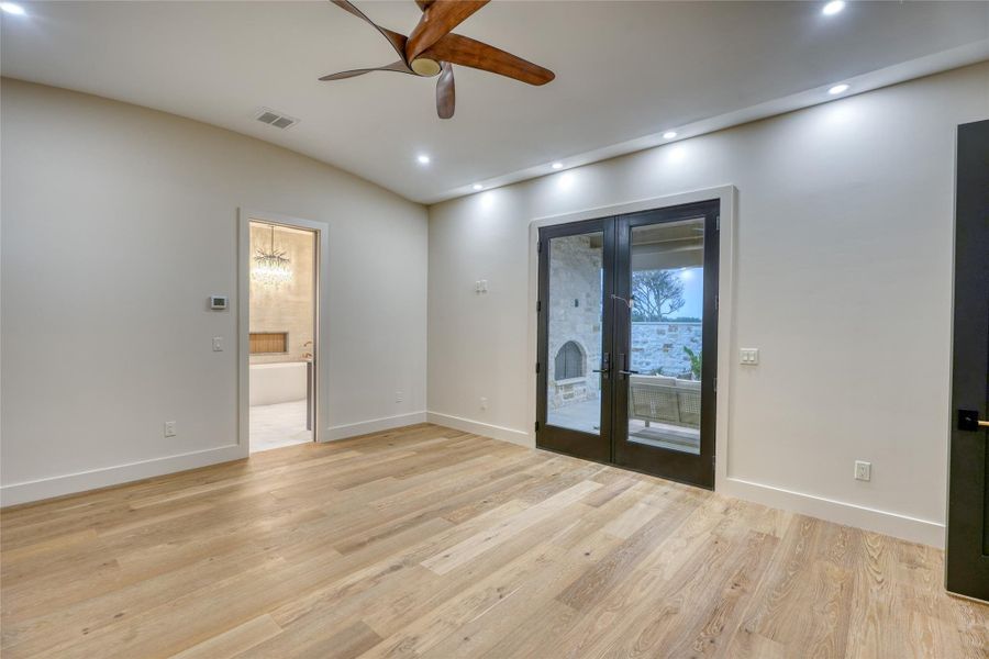 Primary bedroom has French doors that lead to large covered patio with fireplace & backyard pool area.