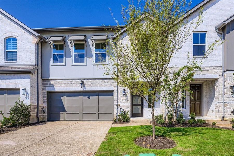 French provincial home featuring stone siding, concrete driveway, a garage, and a front lawn French provincial home featuring stone siding, concrete driveway, a garage, and a front lawn