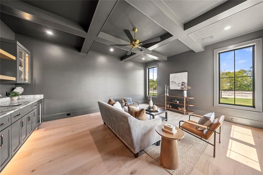 Living room with coffered ceiling, a ceiling fan, beamed ceiling, recessed lighting, and light wood-type flooring
