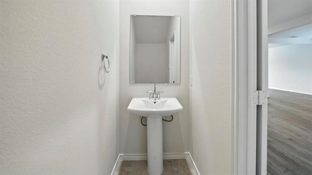 Half bath featuring baseboards and wood finished floors Half bath featuring baseboards and wood finished floors