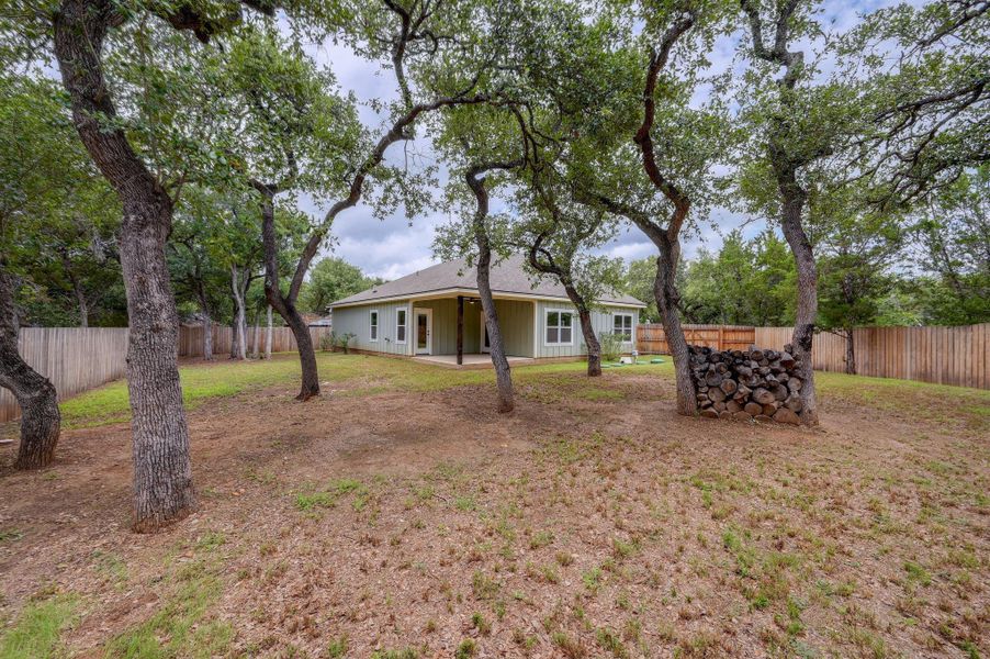 A private backyard oasis with mature trees and a tranquil covered patio. A private backyard oasis with mature trees and a tranquil covered patio.