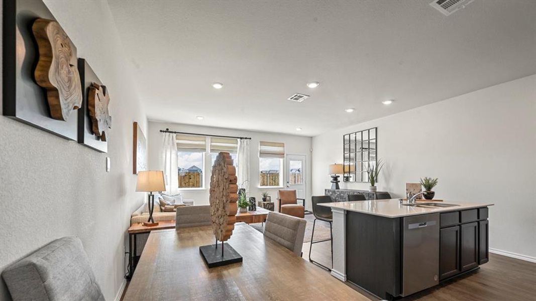 Kitchen with open floor plan, a kitchen island with sink, dark wood-style flooring, stainless steel dishwasher, and recessed lighting