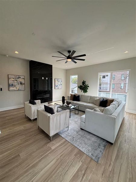 Living area featuring light wood-style floors, recessed lighting, and a ceiling fan Living area featuring light wood-style floors, recessed lighting, and a ceiling fan