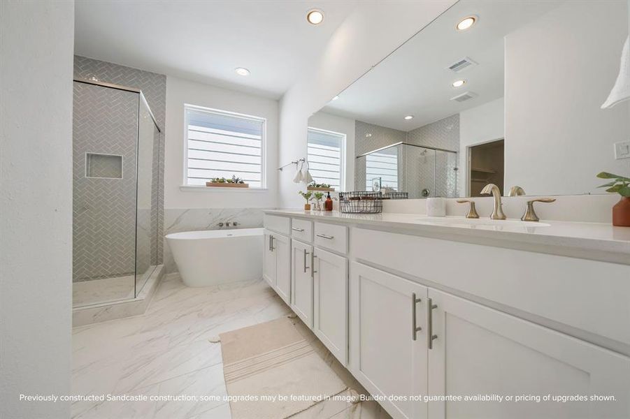 Spa-Like Primary Bathroom – Indulge in luxury with a freestanding soaking tub, herringbone-tiled shower, and double vanities with quartz countertops.