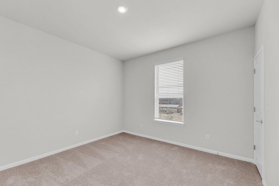 Empty room featuring light carpet and baseboards