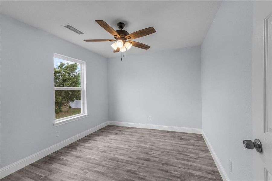 Empty room featuring a ceiling fan and wood finished floors