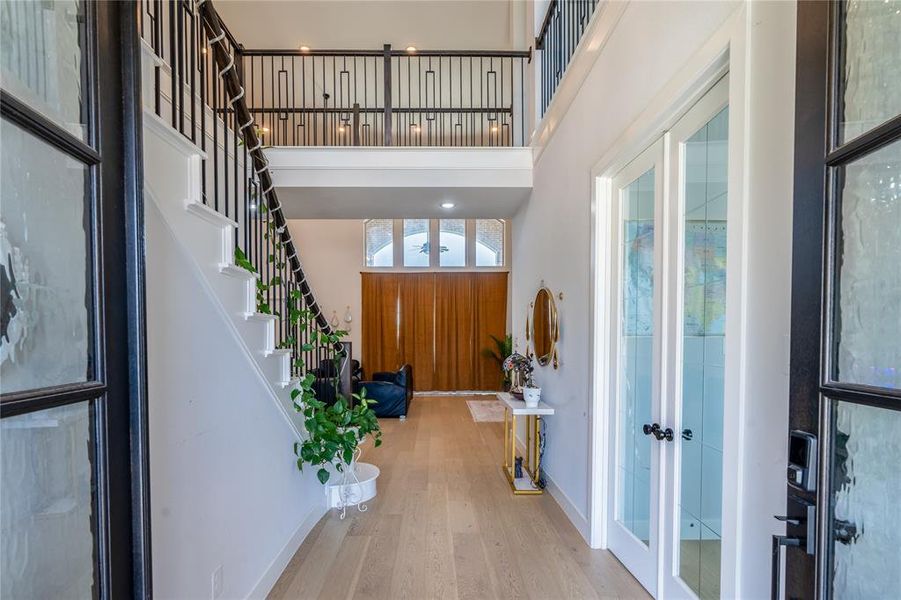 Foyer with a high ceiling, wood finished floors, and french doors