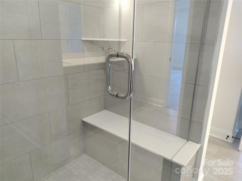 Relax on this tiled bench seat inside the luxurious 5' walk-in shower! Representative Photo