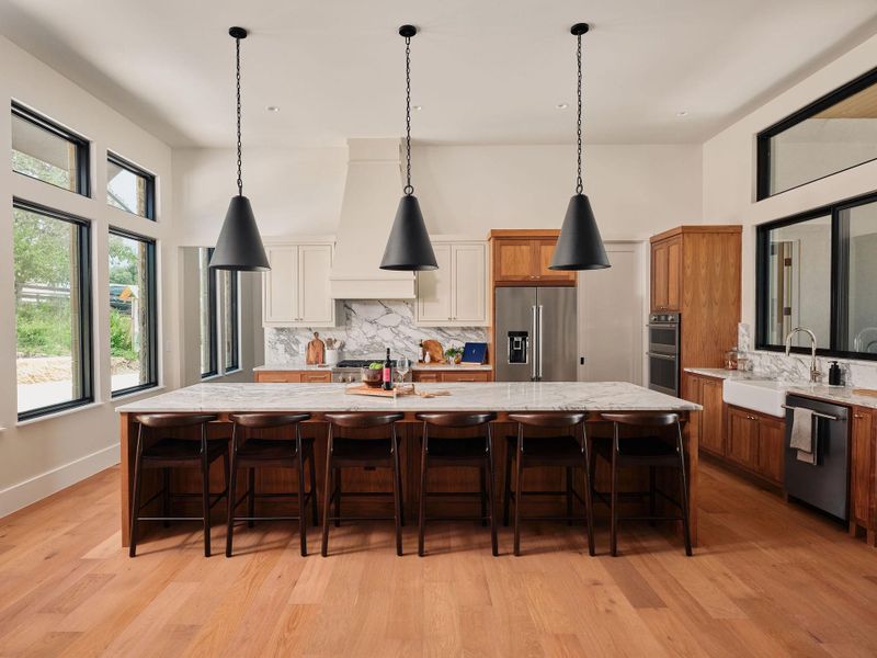 A grand central island anchors this spacious kitchen, boasting premium appliances and abundant natural light. A grand central island anchors this spacious kitchen, boasting premium appliances and abundant natural light.