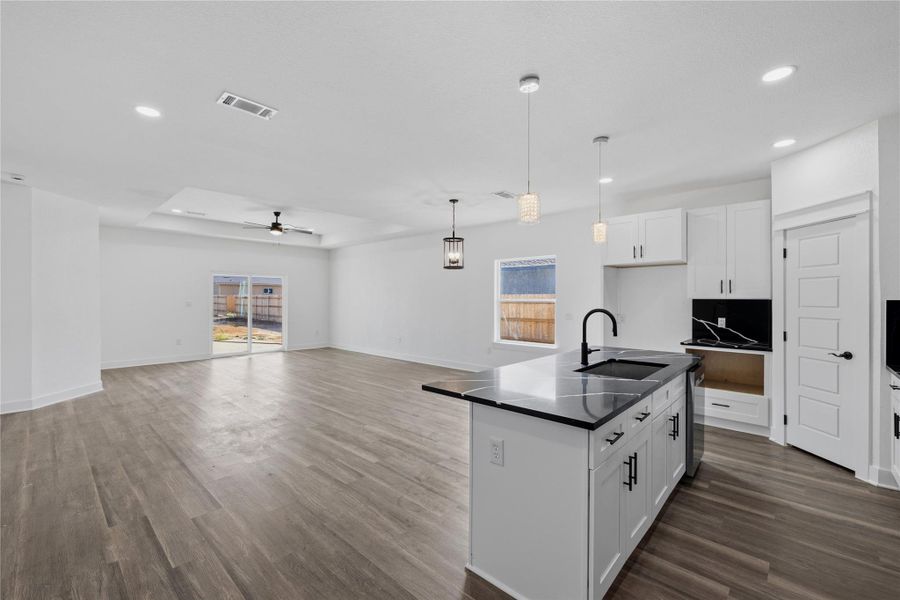 Center island with open floor plan and white cabinetry