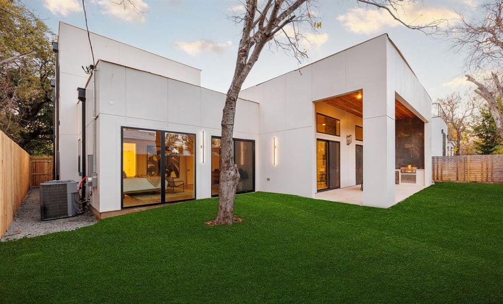 Back of property featuring a lawn, cooling unit, and a patio