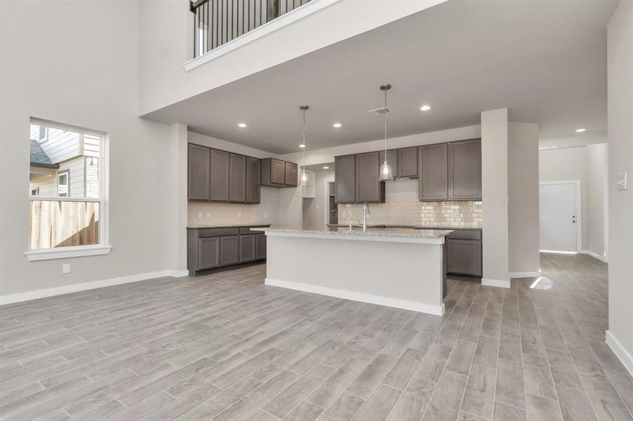 Take another glimpse into the heart of the home with this additional view of the family room—a sprawling space ready to accommodate all your gatherings. Sample photo of completed home with similar floor plan. As-built interior colors and selections may vary.