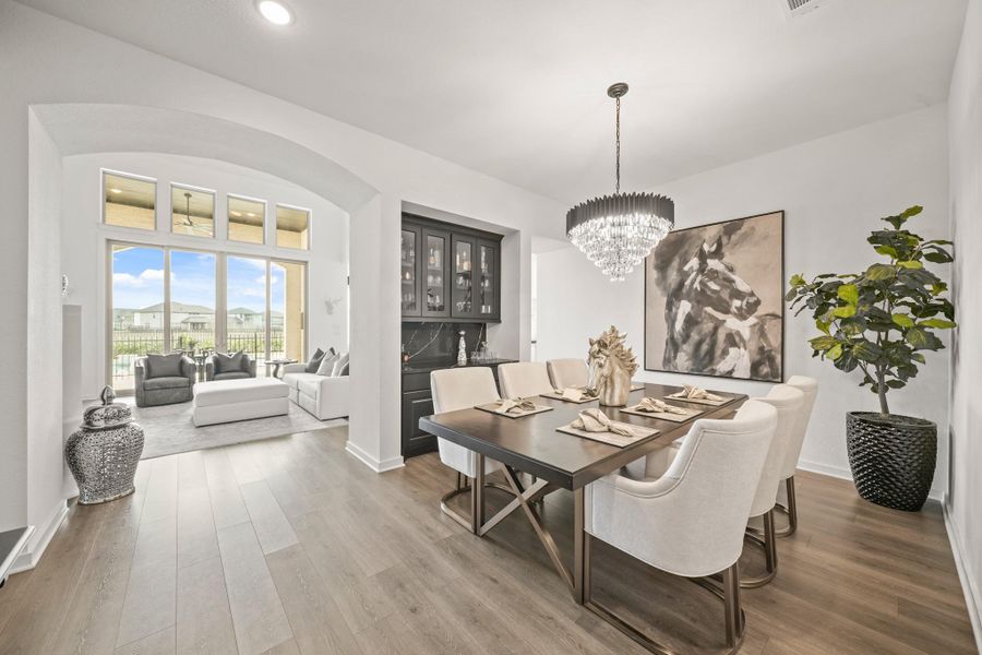 The view from the dining area with an arched entrance into the spacious family room leads to the outdoor living area, pool and spa. The entrance to the far right takes you into the kitchen.