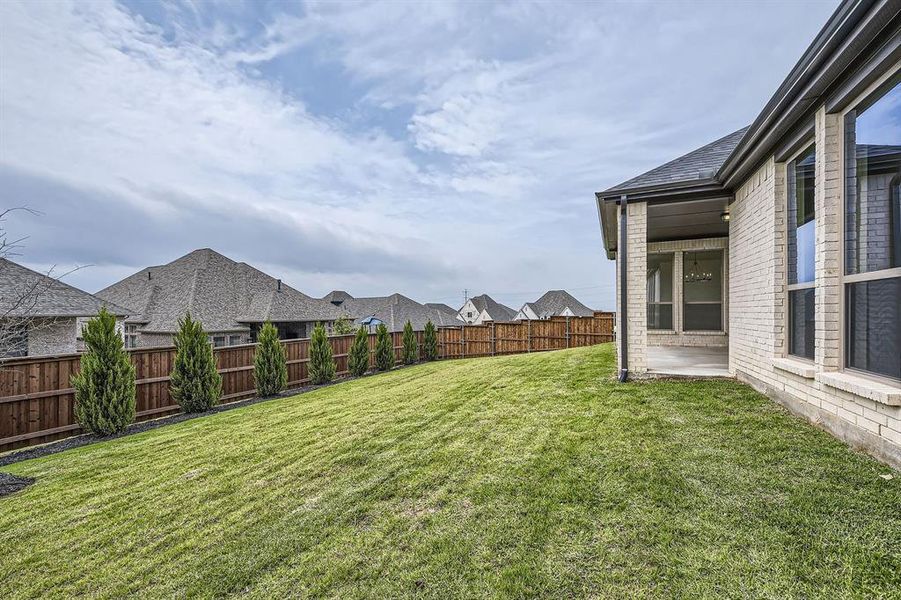 Fenced backyard featuring a patio and a residential view
