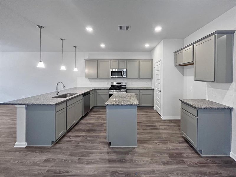 The Sparrow II- Kitchen with center island and ample counter/cabinet space. Sample photo used for illustrative purposes only, options/colors will vary.