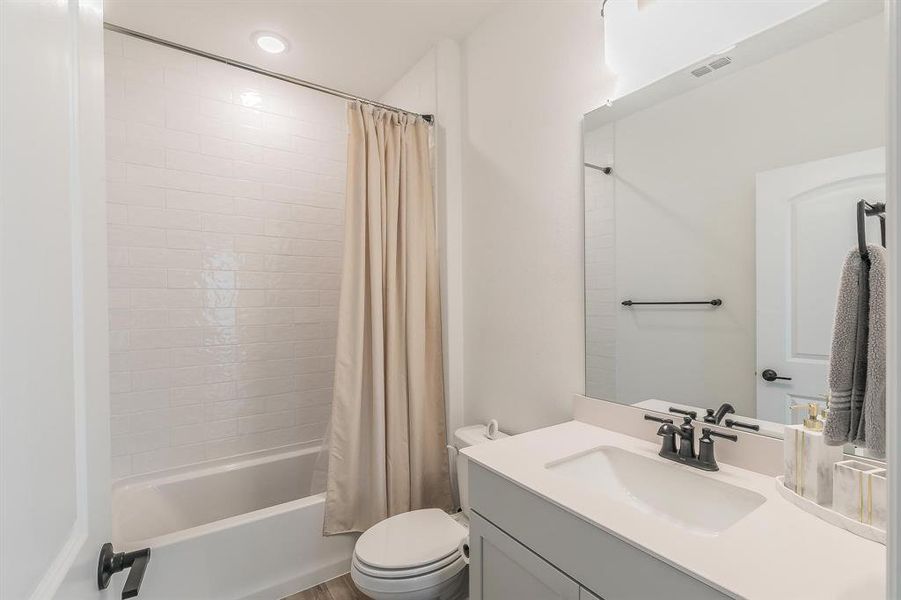 Full bathroom with shower / bath combo, vanity, and toilet