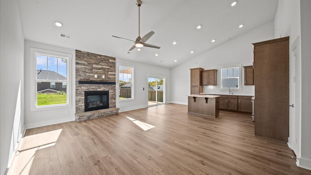 Eye-catching two-story family room with fireplace, elegant trim, oversized windows, and elevated design