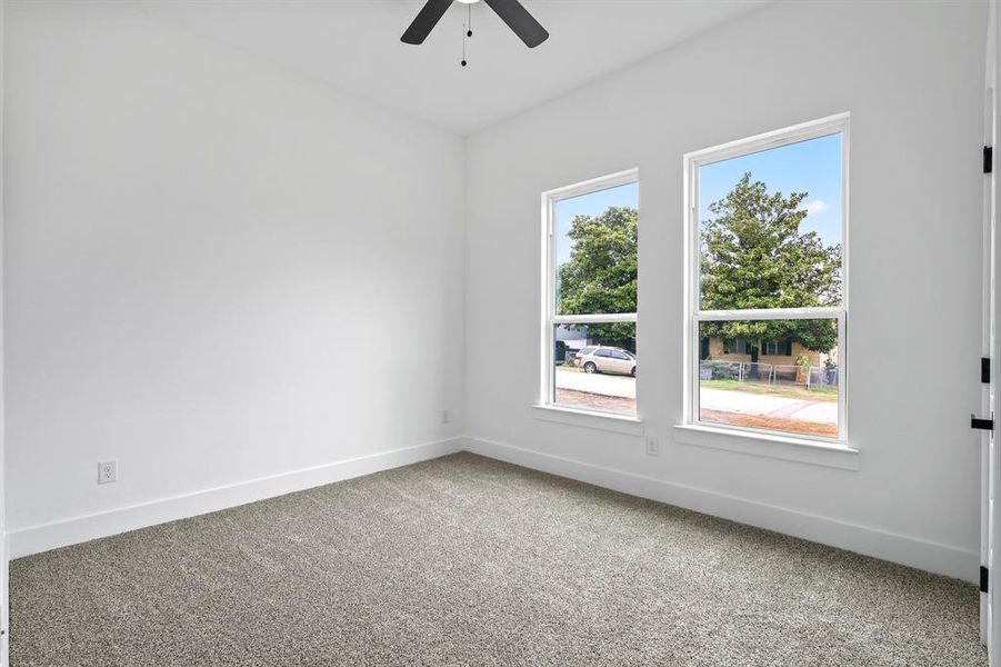 Carpeted empty room with ceiling fan