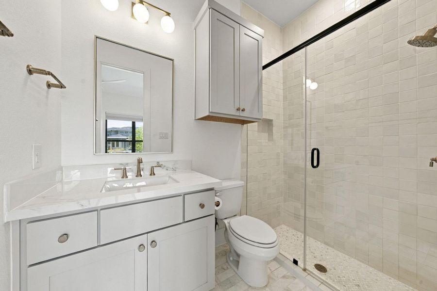 This attached bath offers a spacious shower and a well-appointed vanity, giving this secondary bedroom full privacy.