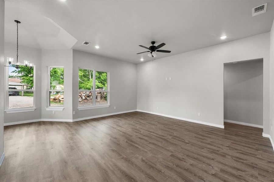 Spacious room featuring wood-finish flooring, light gray wall paint, and white trim
