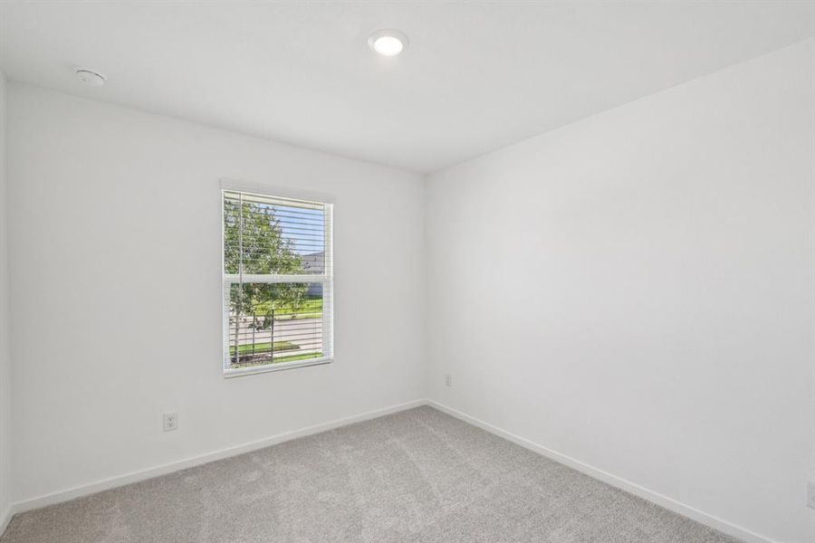 Spare room with light colored carpet and a smoke detector Spare room with light colored carpet and a smoke detector