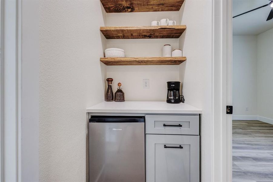 Bar with stainless steel fridge and hardwood / wood-style flooring