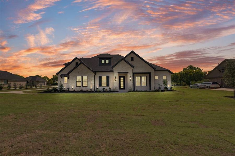 Modern farmhouse with stone siding and a yard