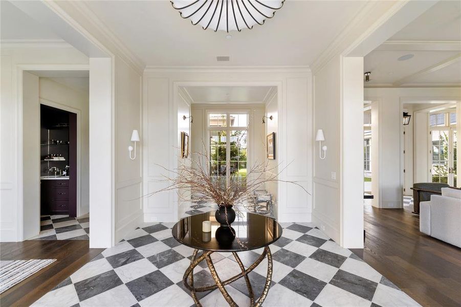 Entryway featuring a decorative wall, dark wood finished floors, and ornamental molding Entryway featuring a decorative wall, dark wood finished floors, and ornamental molding