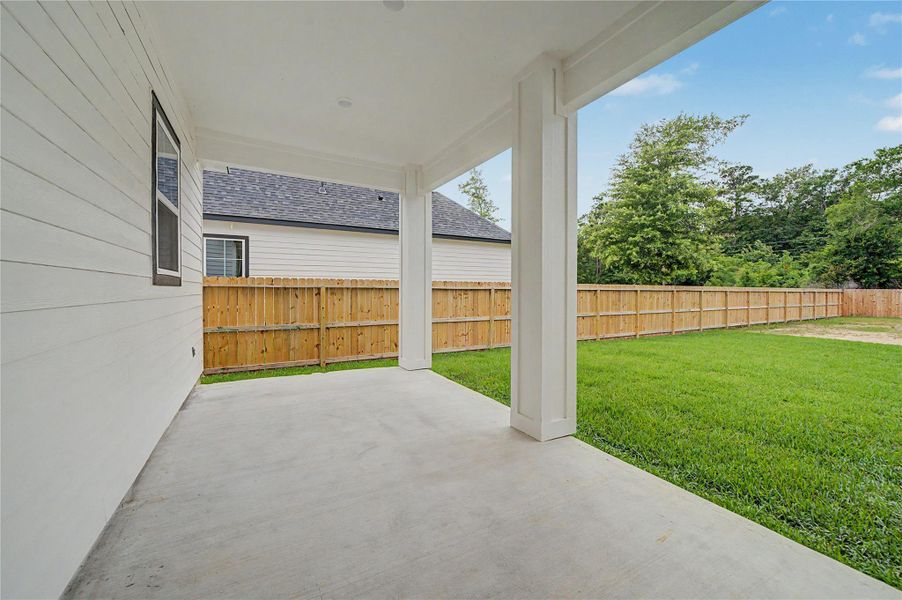 Covered back patio offers a comfortable space for morning coffee, grilling, or relaxing outdoors.