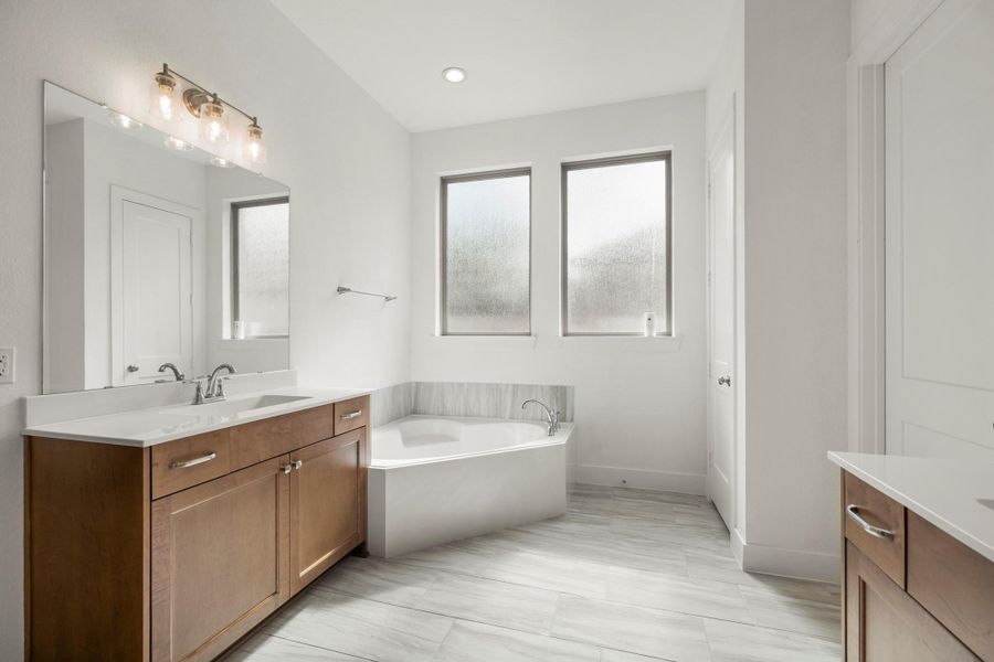 A spa sized garden tub with tile surround sits separately and is tucked into a nook, allowing for a tranquil retreat! A spa sized garden tub with tile surround sits separately and is tucked into a nook, allowing for a tranquil retreat!