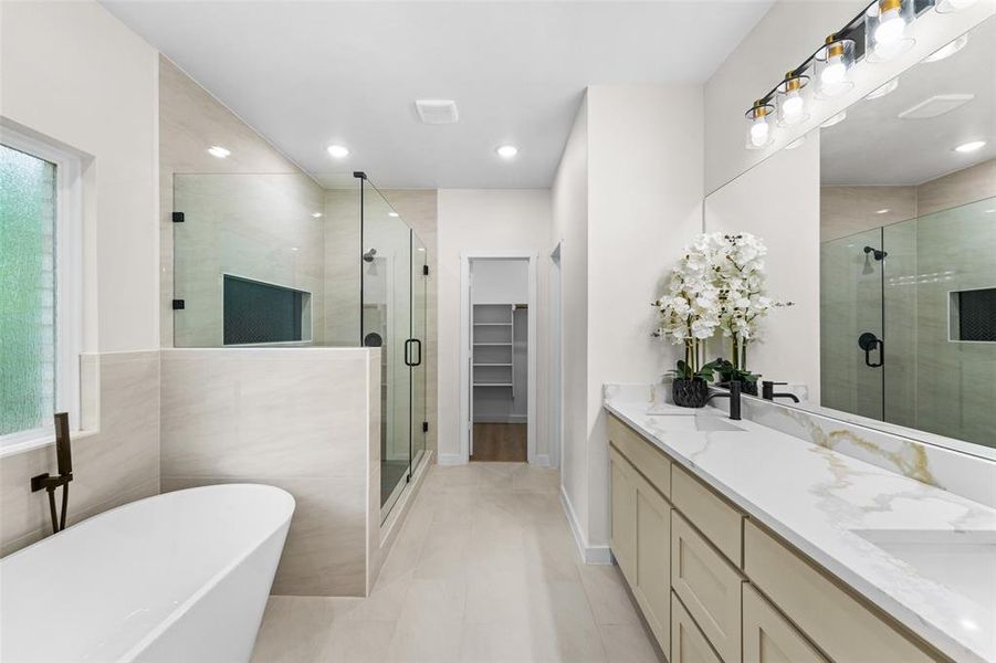 Spacious bathroom featuring a freestanding soaking tub with a wall-mounted faucet, a glass-enclosed shower with a recessed niche, a double vanity with a marble-finish countertop, and a large mirror with overhead lighting Spacious bathroom featuring a freestanding soaking tub with a wall-mounted faucet, a glass-enclosed shower with a recessed niche, a double vanity with a marble-finish countertop, and a large mirror with overhead lighting