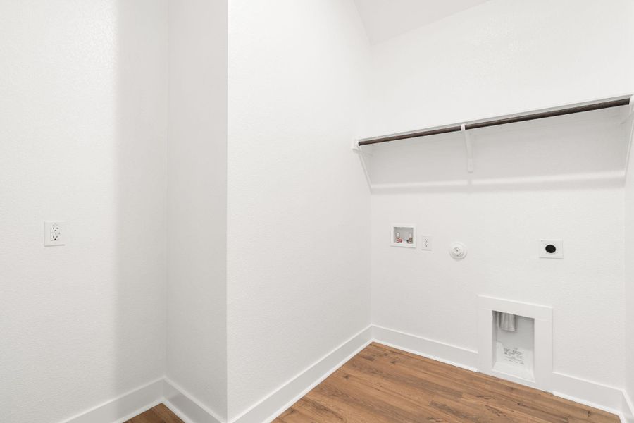 A laundry room with convenient overhead shelving.