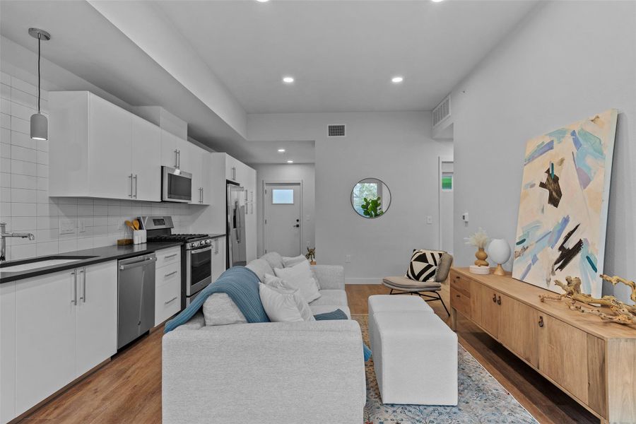 Living room featuring baseboards, visible vents, dark wood-type flooring, and recessed lighting