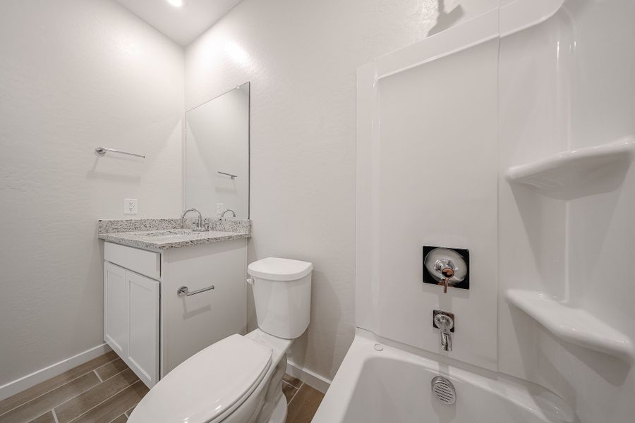 A bathroom with a tub toilet and sink. A bathroom with a tub toilet and sink.